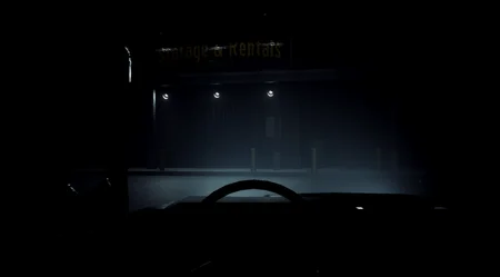 Exterior view of the Storage & Rentals building at night from inside a car